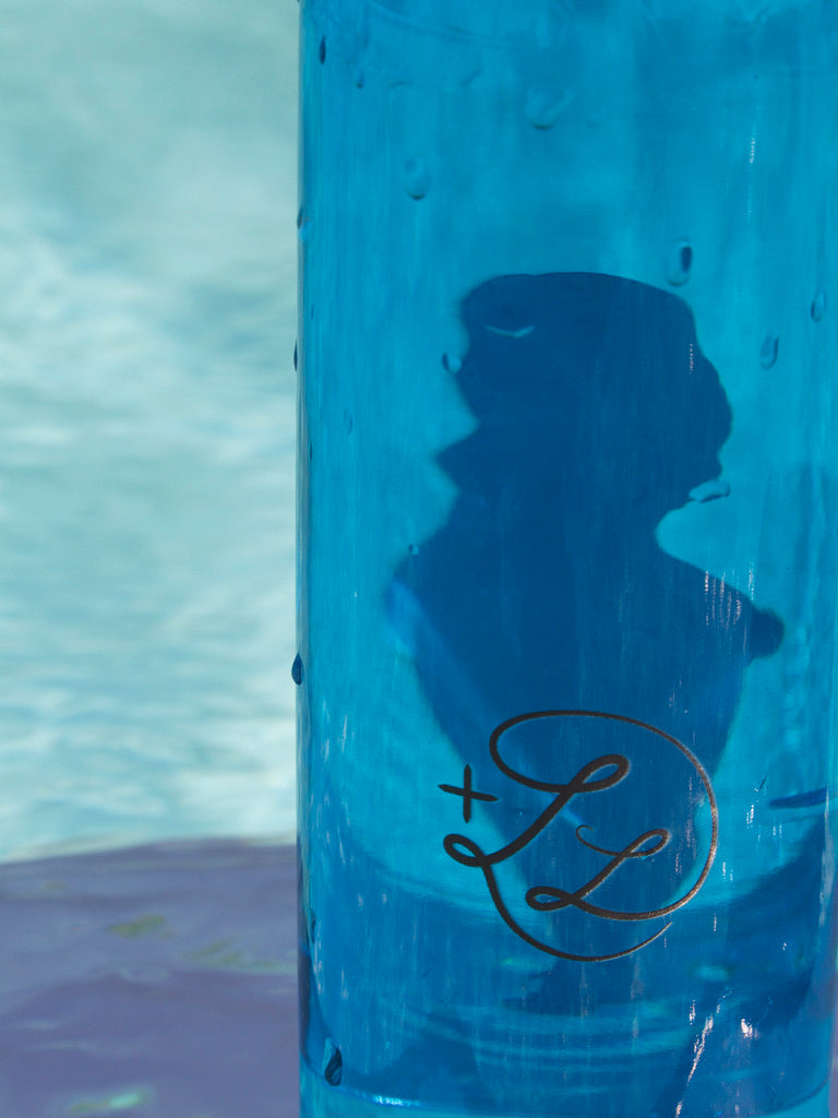 Zoom logo gourde plusdelles femme bleue derrière